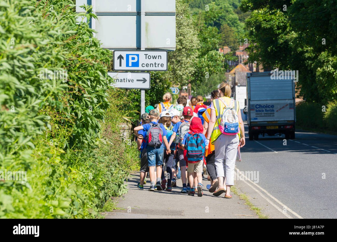 Group of school children being taken to school in the morning in the UK. Stock Photo