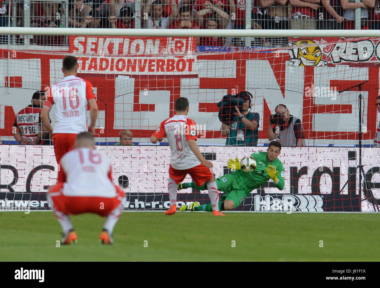 Munich's goalkeeper Stefan Ortega Moreno (R) catches the penalty shot by  Andreas Geipl of Regensburg (2-R) during the 2. Bundesliga relegation match  between Jahn Regensburg and TSV 1860 Munich at the Continental
