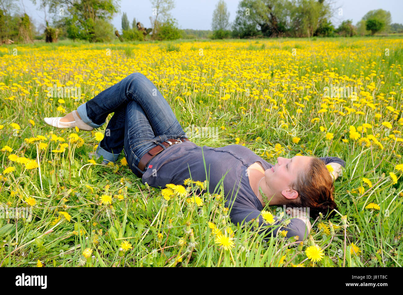 young woman lying on a flower meadow Stock Photo