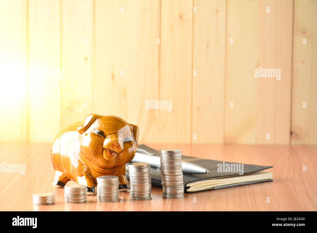 Stack coins, calculator and piggy bank on wood table and copy space ...