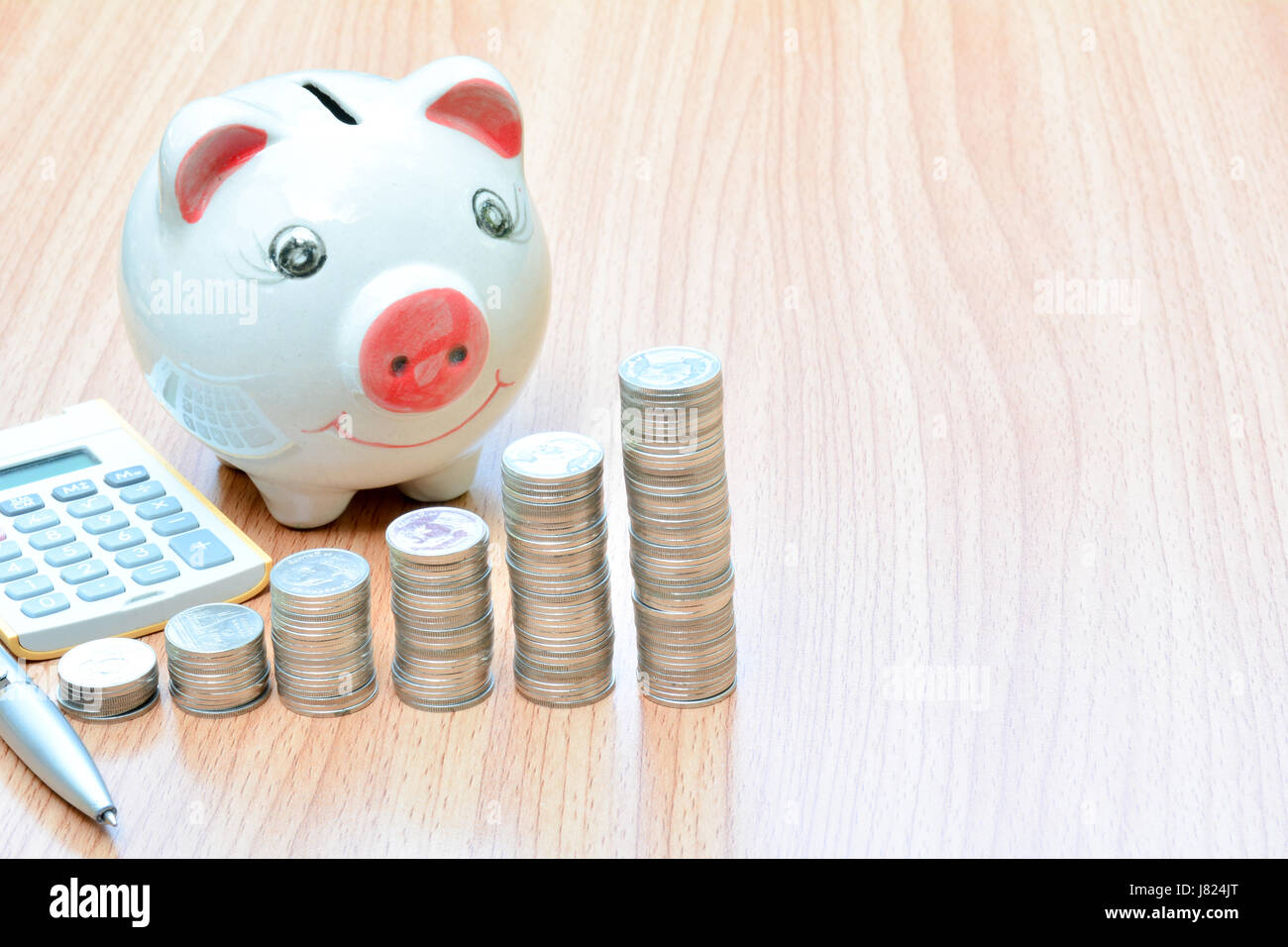 Finance stack coins and piggy bank on wood table Stock Photo - Alamy