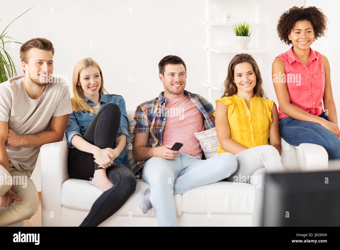 happy friends with remote watching tv at home Stock Photo - Alamy