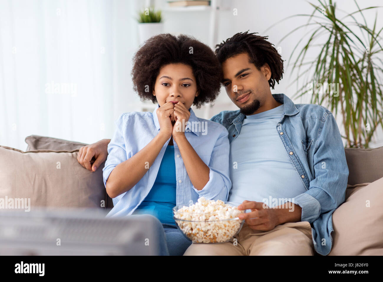 happy couple with popcorn watching tv at home Stock Photo - Alamy