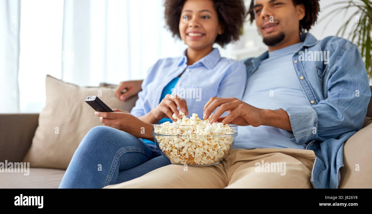 smiling couple with popcorn watching tv at home Stock Photo - Alamy