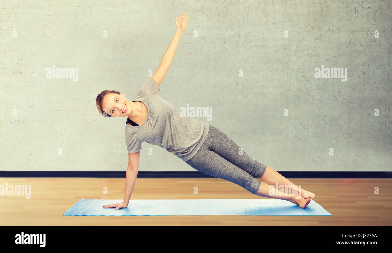 woman making yoga in side plank pose on mat Stock Photo - Alamy