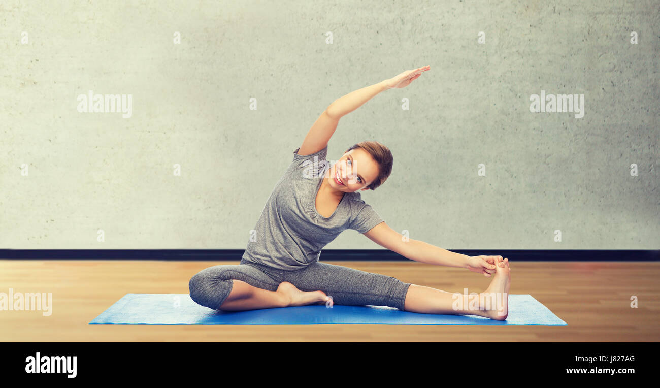 happy woman making yoga and stretching on mat Stock Photo - Alamy