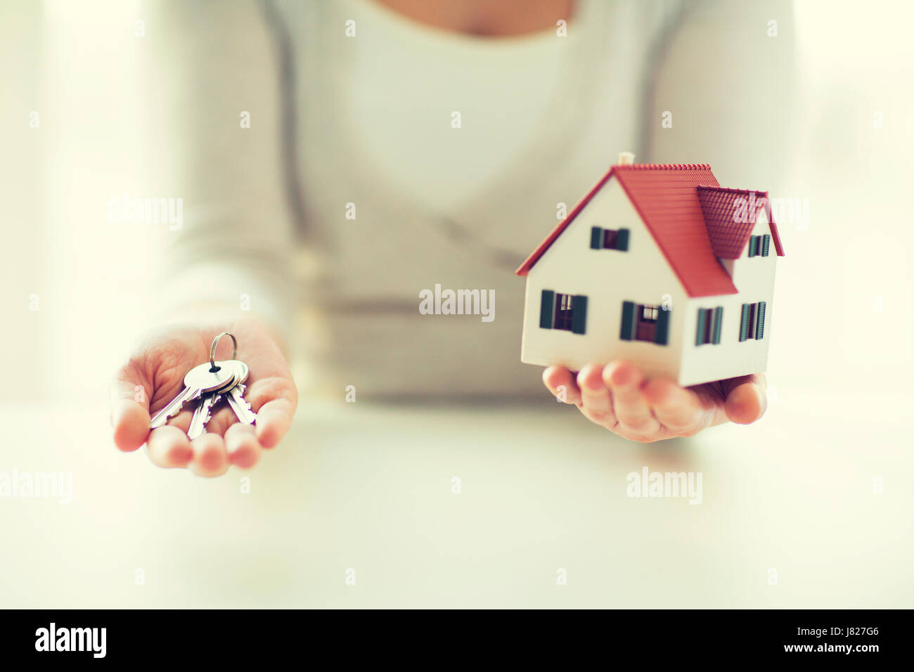close up of hands holding house model and keys Stock Photo - Alamy