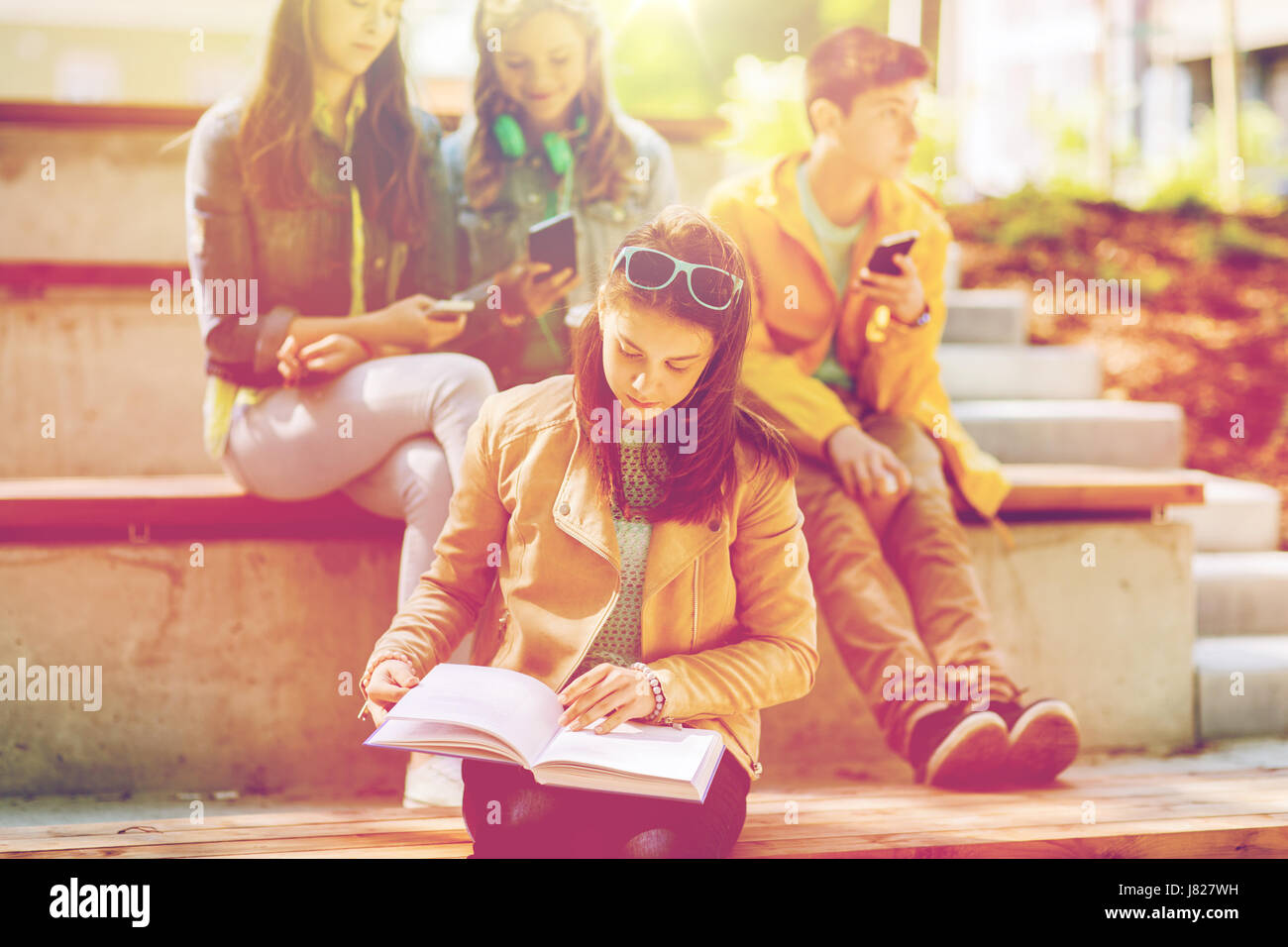 high school student girl reading book outdoors Stock Photo