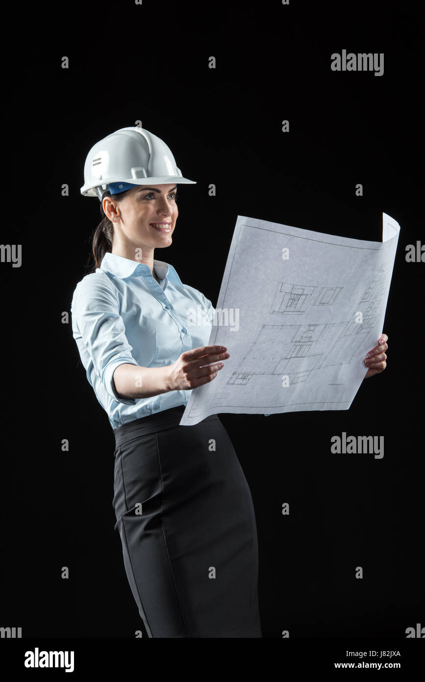 Smiling female architect in helmet holding blueprint Stock Photo - Alamy