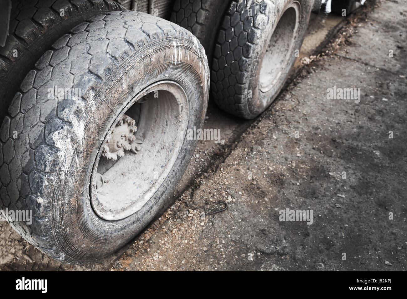Cargo truck wheels on dirty asphalt road Stock Photo
