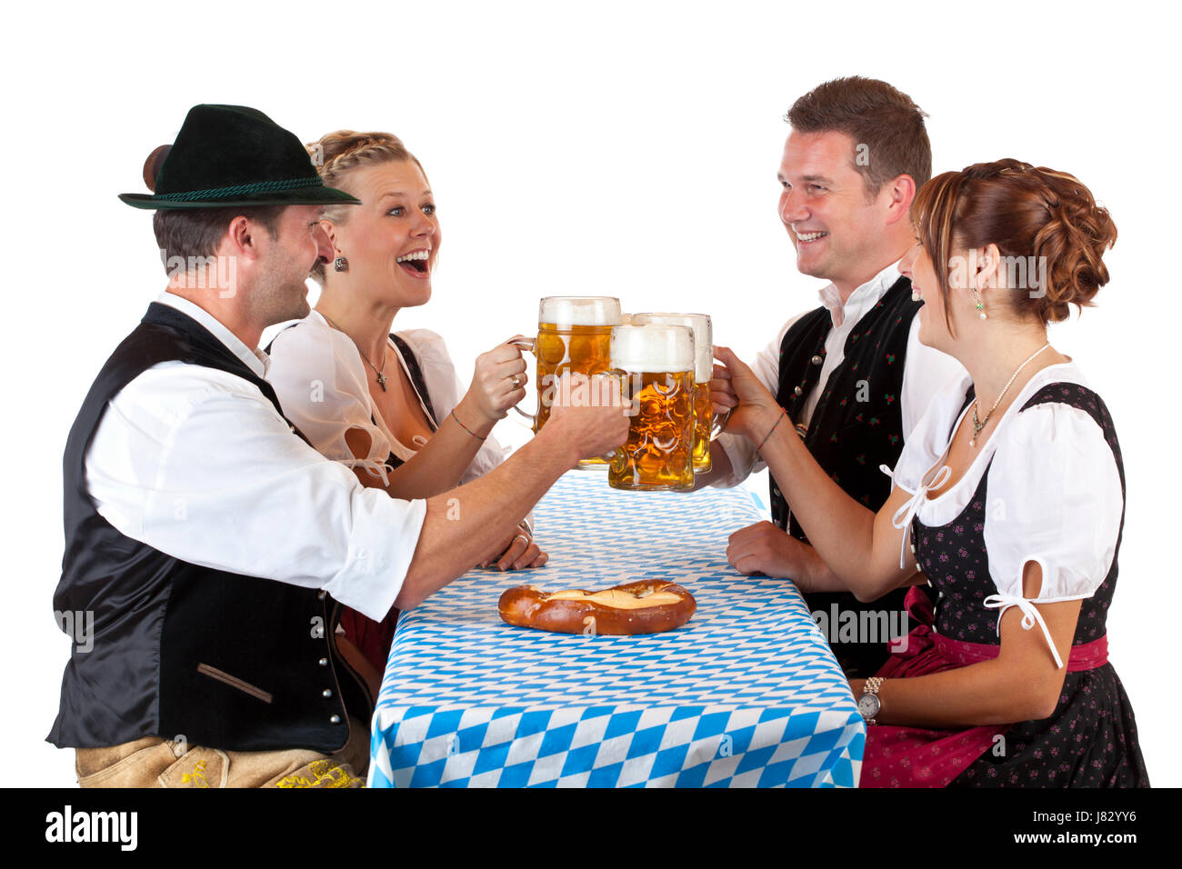 bavarian men and women clinking oktoberfest stein of beer at Stock Photo