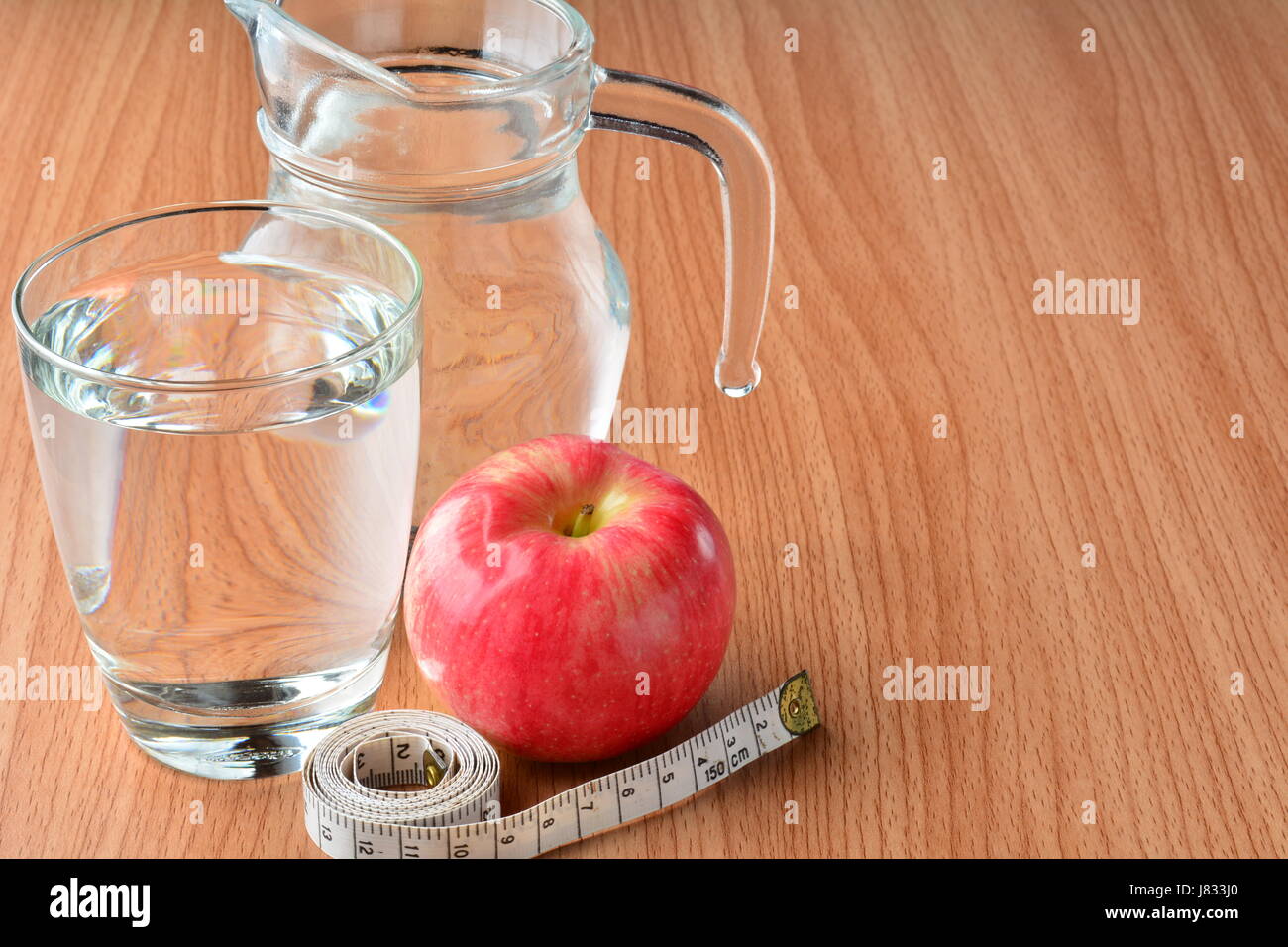 measuring tape, apple and water glass for healthy and body slim Stock Photo