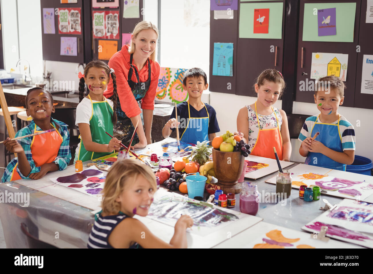 Portrait of smiling teacher and schoolkids in drawing class Stock Photo ...