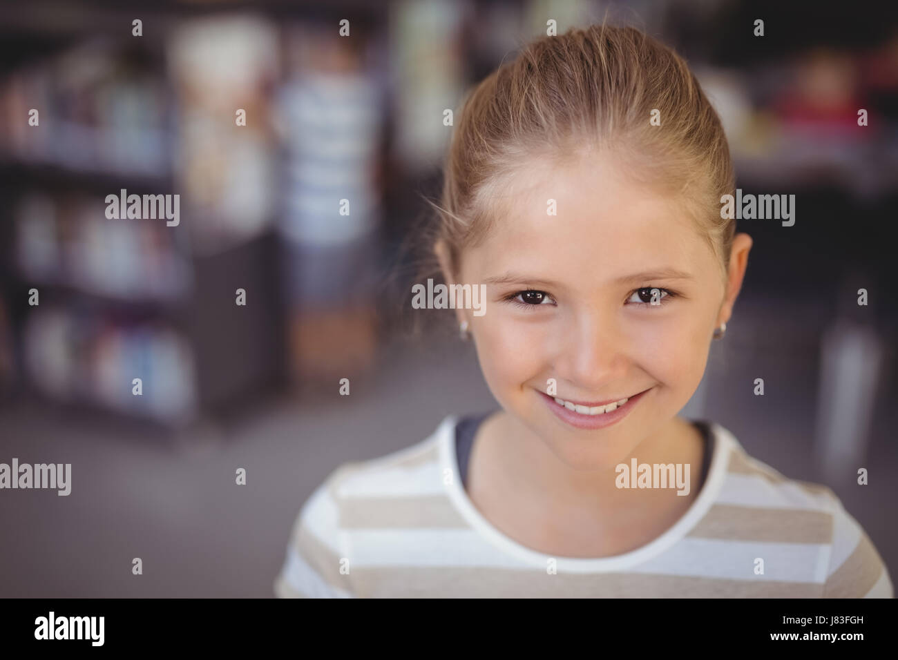 Portrait of smiling schoolgirl in library at school Stock Photo - Alamy