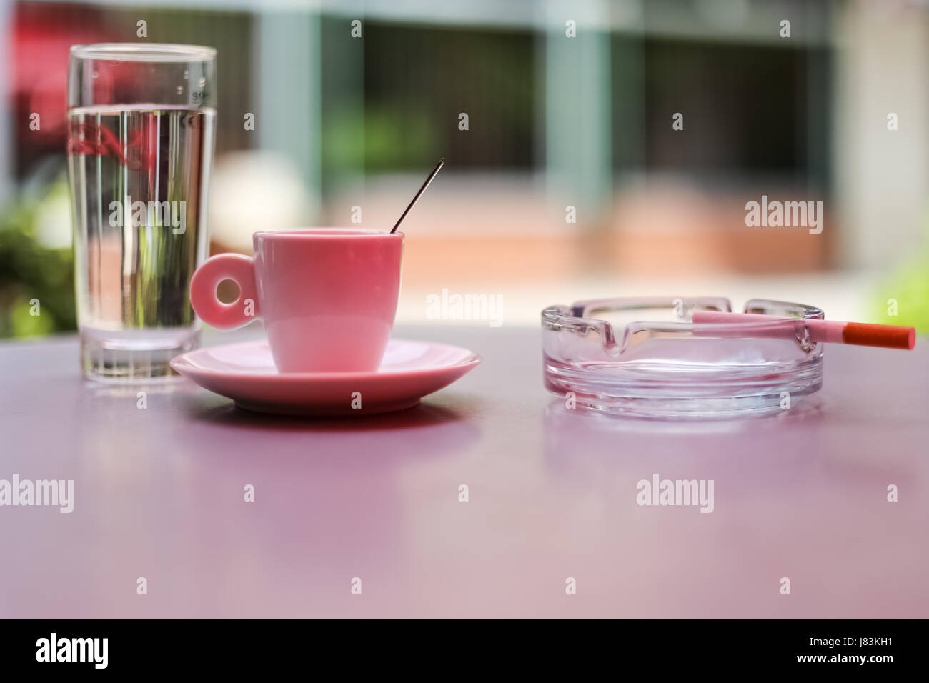 balkan breakfast cigarette and coffee Balkan way of drinking coffee, cup of coffee, cigarettes, ashtrays, glasses  of water, served at table Stock Photo