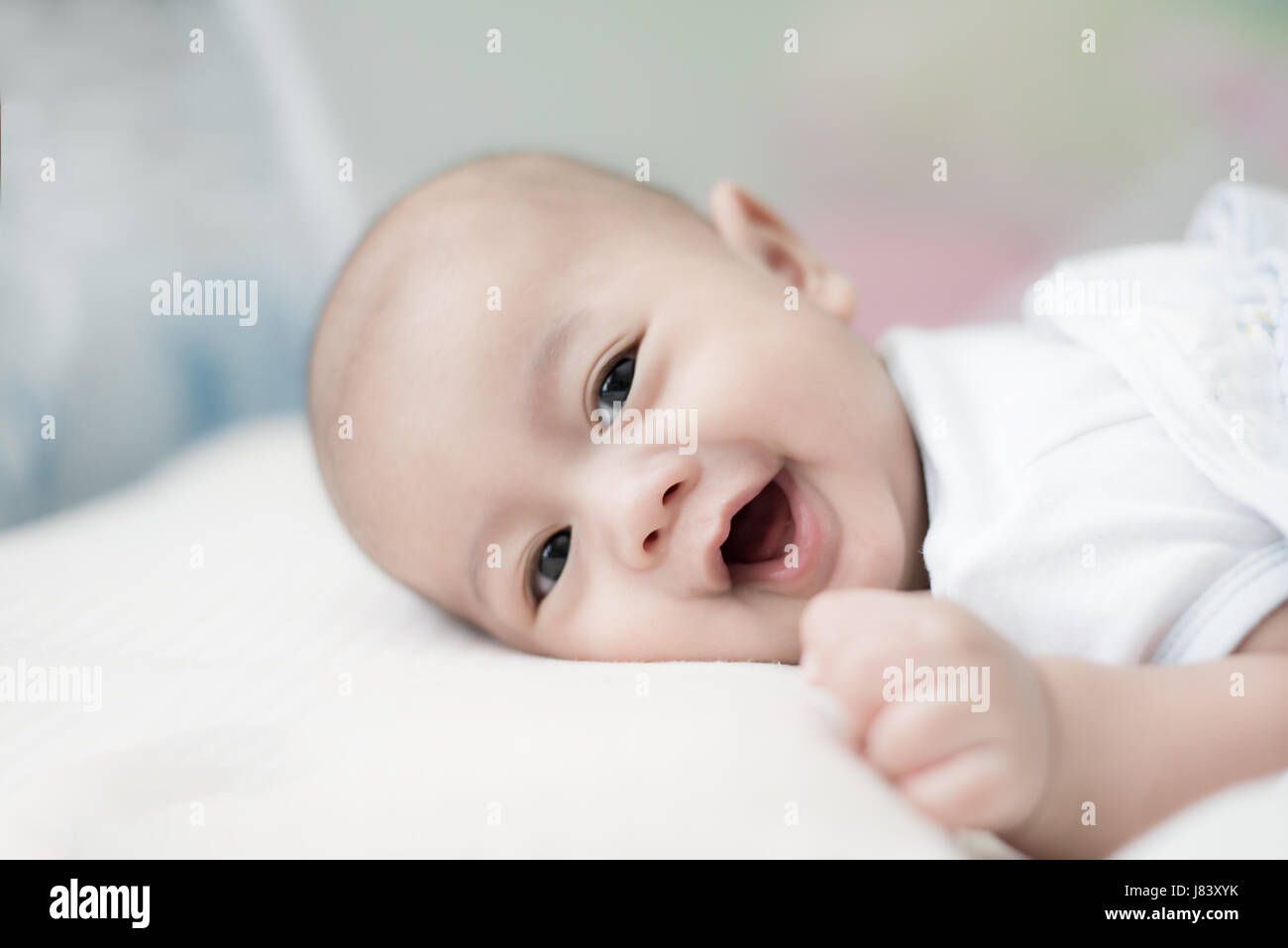 Portrait of cute 3 months Asian baby boy lying down on a blanket and smile. Stock Photo