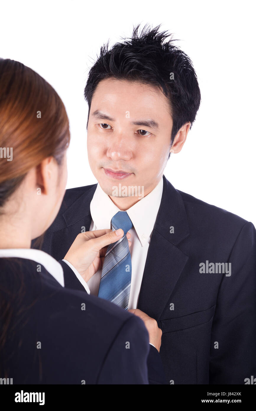business woman's hands adjusting neck tie of man in suit isolated on white background Stock Photo