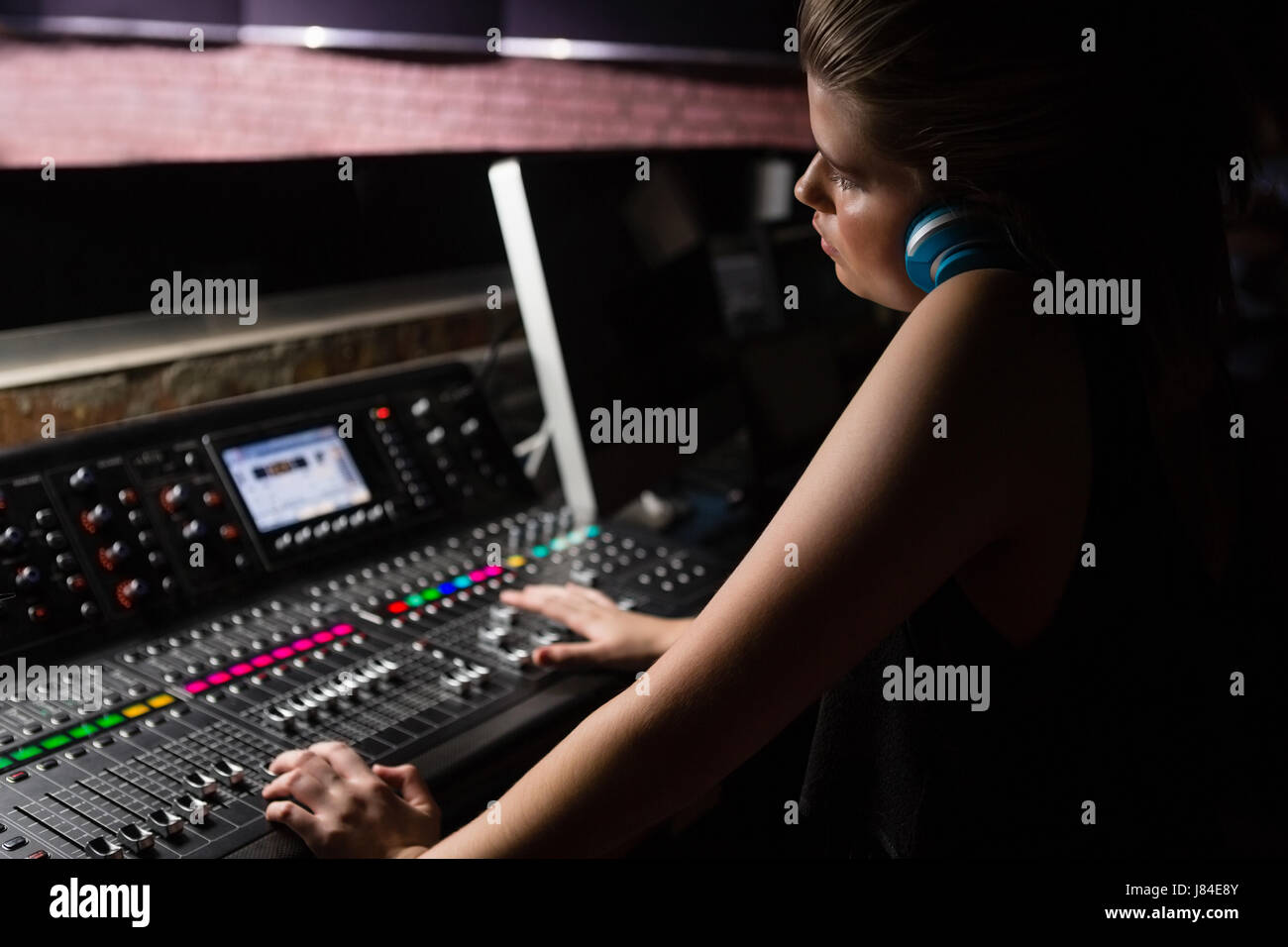 Female audio engineer using sound mixer in recording studio Stock Photo