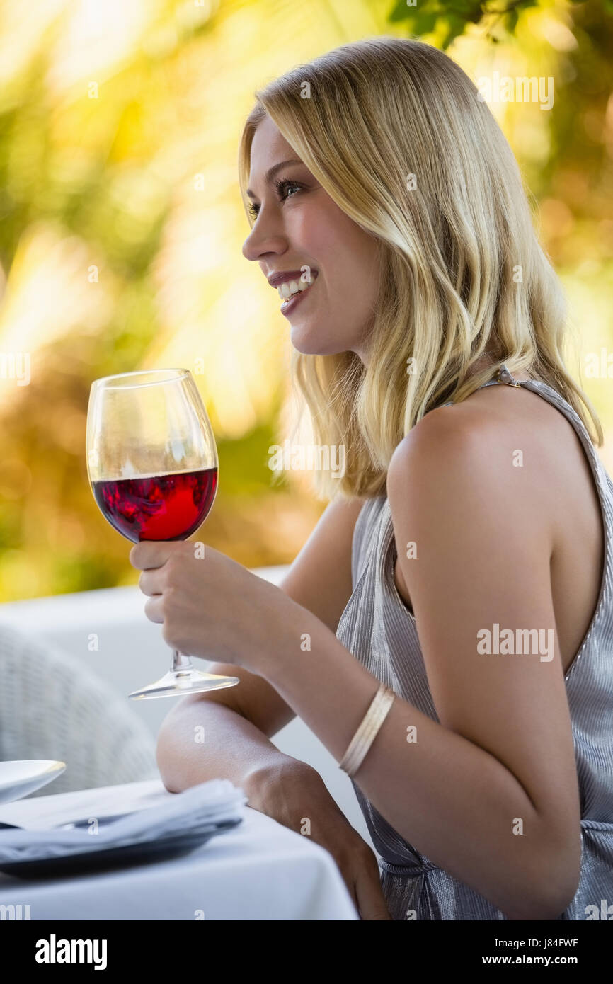 Side view of attractive woman holding red wine glass at restaurant Stock  Photo - Alamy