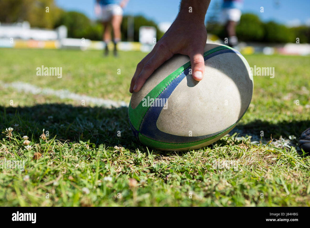 Cropped image of player touching rugby ball at field Stock Photo - Alamy