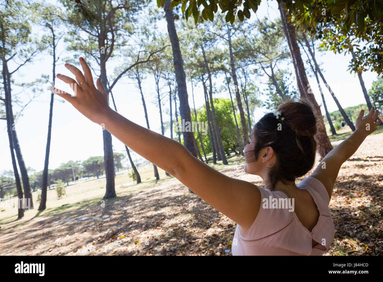 Blissful woman standing with arms outstretched in the park Stock Photo