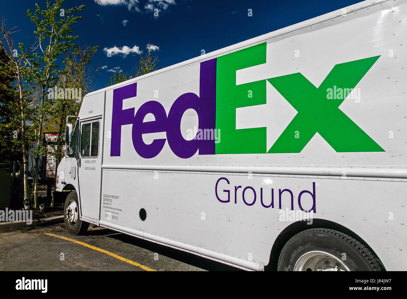 Park City, UT, May 12, 2017: Bright sun shiines on a side of a parked FedEx Ground white truck. Stock Photo