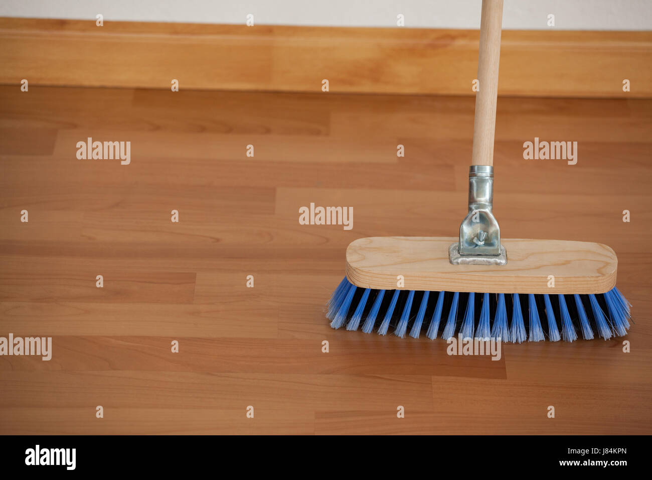 Closeup of sweeping broom with wooden handle on floor Stock Photo Alamy