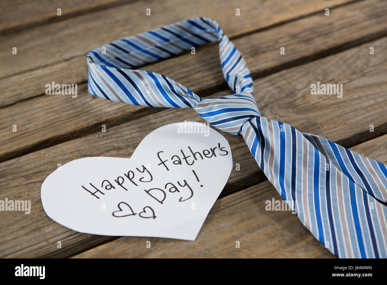 Close Up Of Heart Shape Paper With Text By Necktie On Wooden Table 