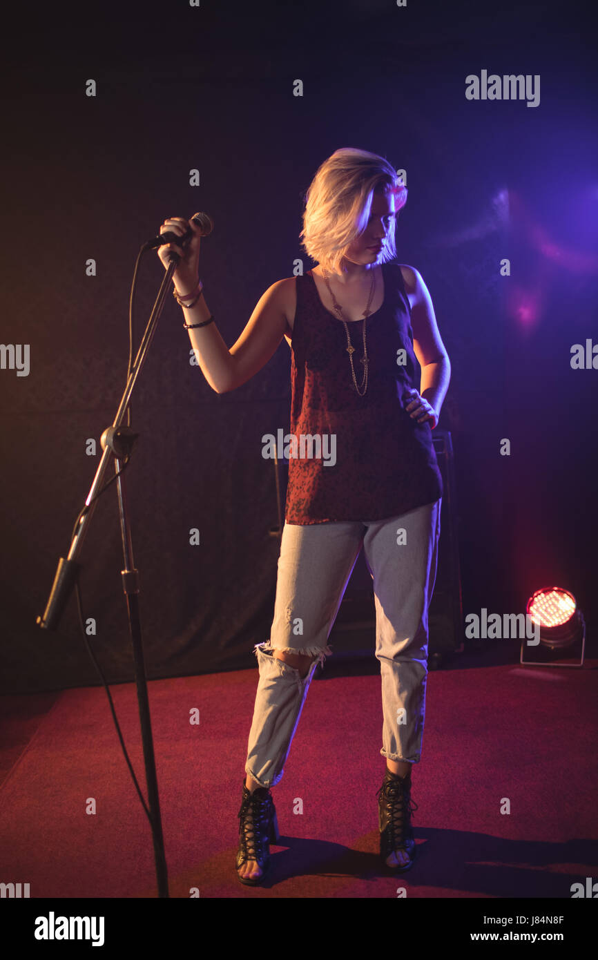 Mid Size Singer Full length of confident female singer holding microphone in ...
