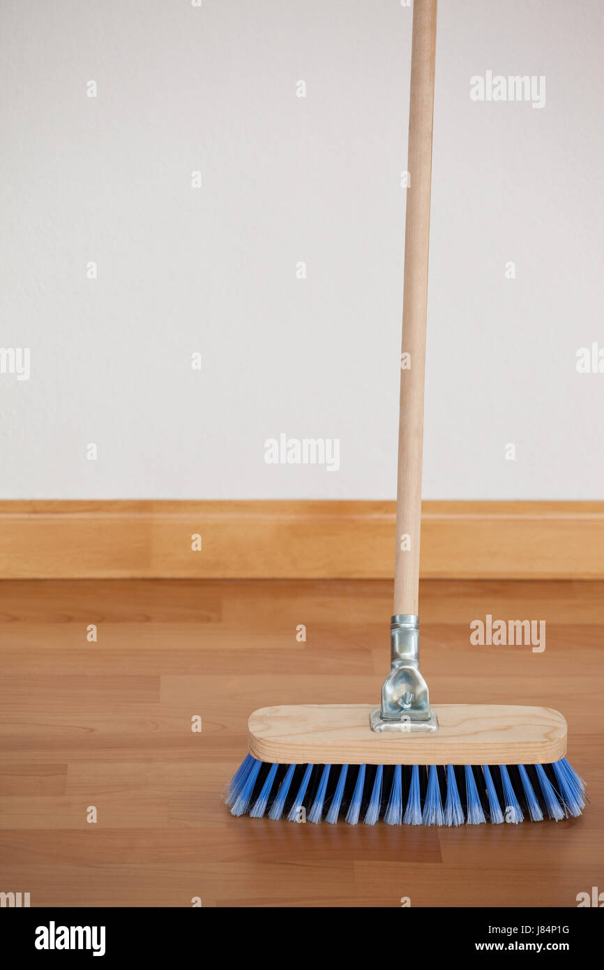 Sweeping broom with wooden handle on floor against wall Stock Photo Alamy