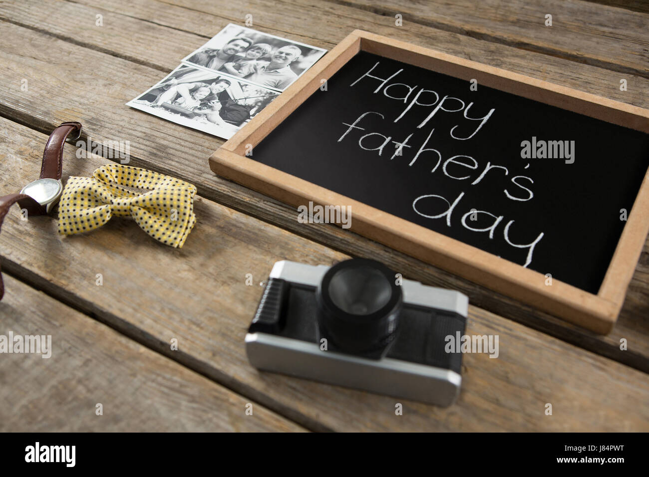 High angle view of slate with text by photographs and camera on wooden table Stock Photo