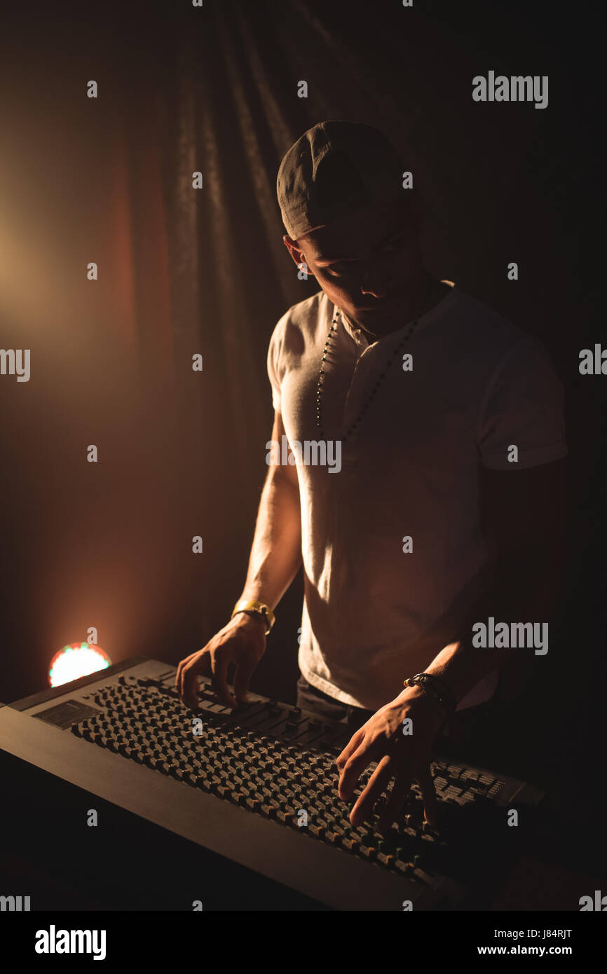 Confident male DJ operating sound mixer at music concert Stock Photo