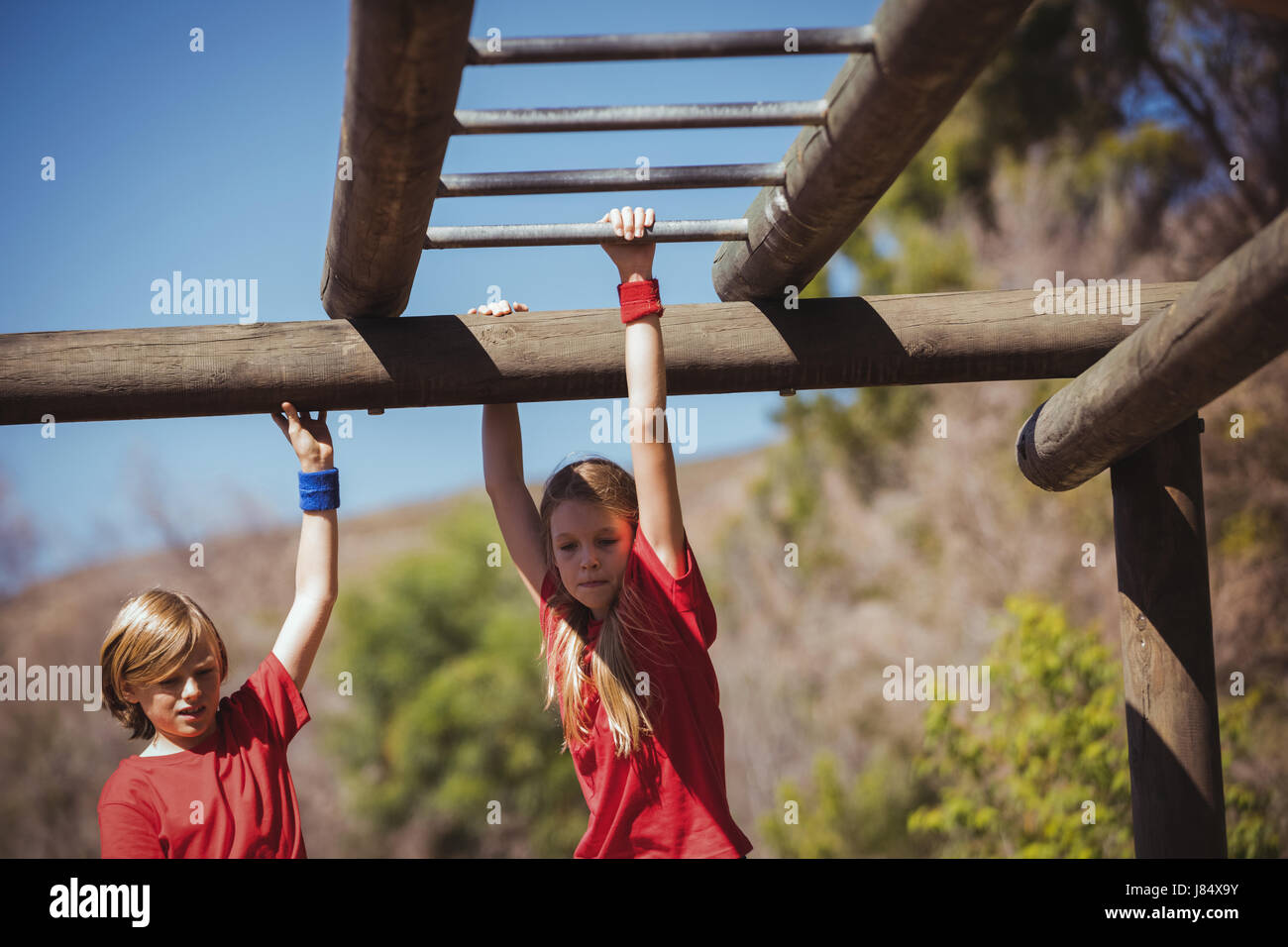 Kids climbing monkey bars during obstacle course training in the boot camp Stock Photo Alamy