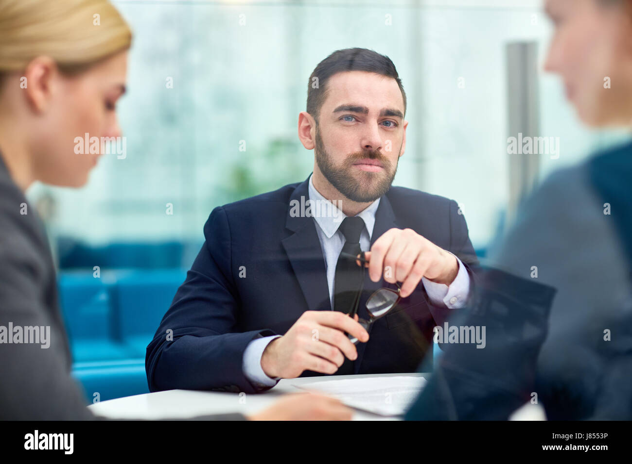 Serious leader looking at camera by workplace Stock Photo - Alamy