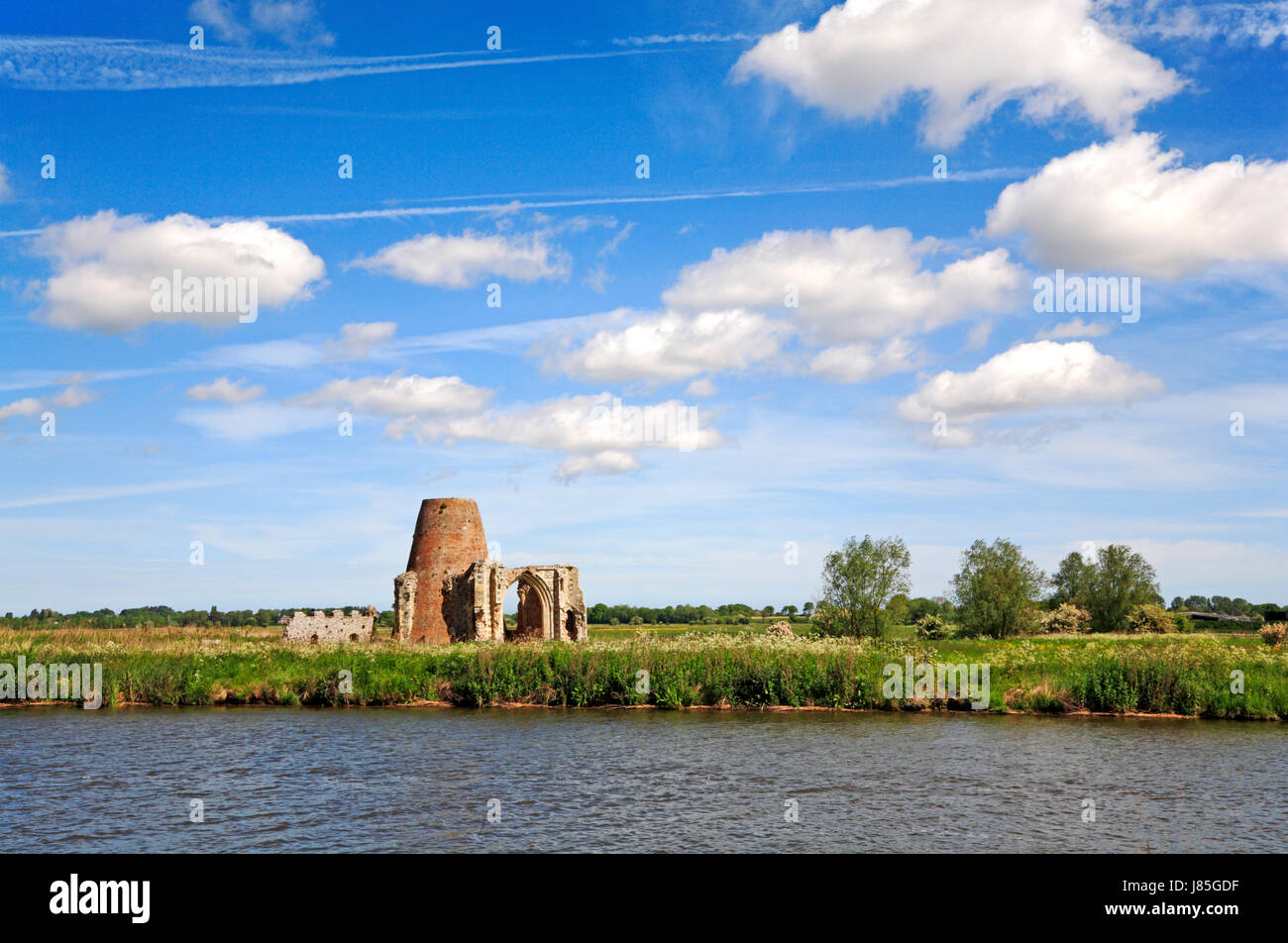 A landscape by the River Bure featuring the disused St Benet's Abbey Drainage Mill and the ruins of the St Benet's Abbey gatehouse. Stock Photo
