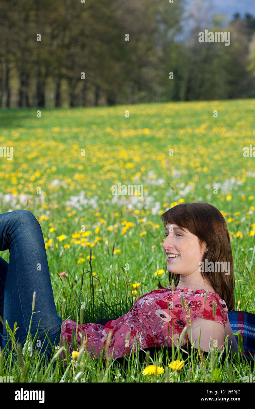 young woman lying on blanket in meadow Stock Photo