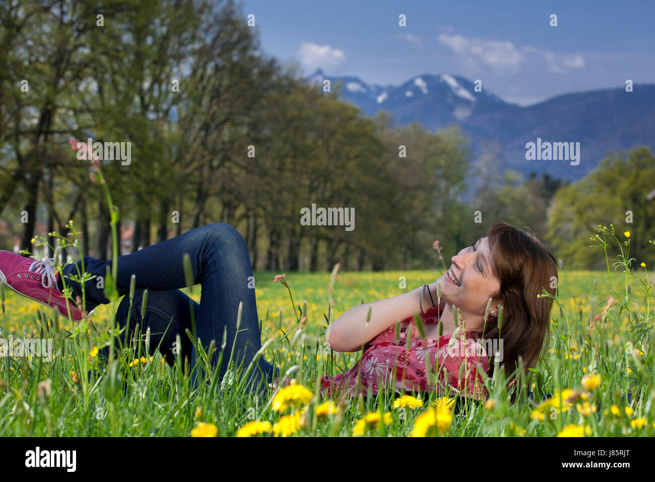 woman legs lie lying lies spring flower meadow young younger meadow girl girls Stock Photo
