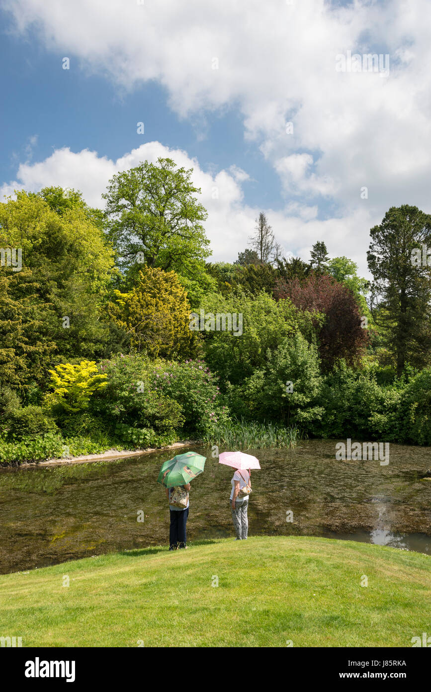 Two ladies beside the Koi lake at Thornbridge hall gardens near Great Longstone, Derbyshire, England. Stock Photo