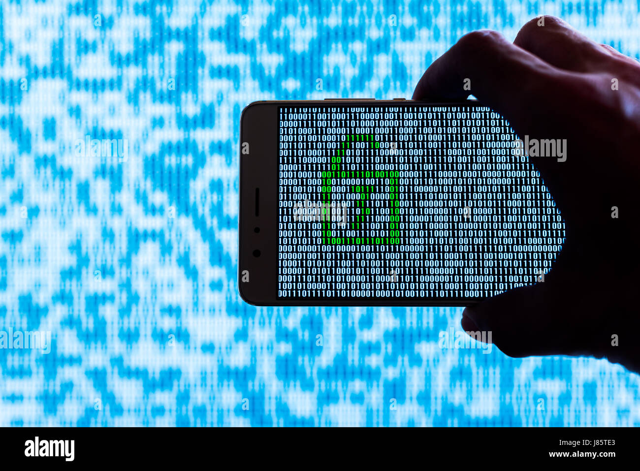 Hand holding a smartphone with a locker unlocked against binary code on screen Stock Photo