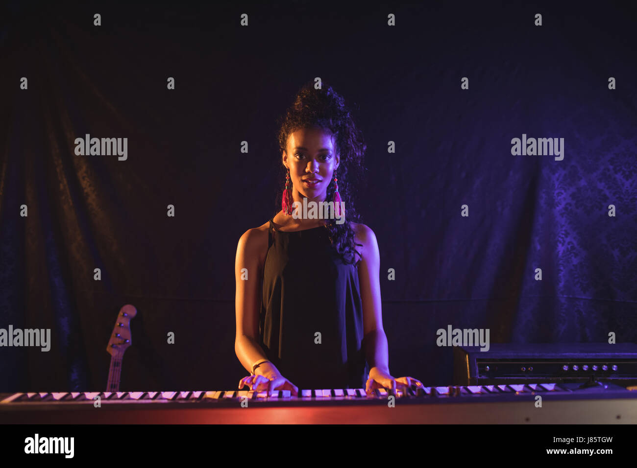 Portrait of female musician playing piano at popular music concert Stock Photo