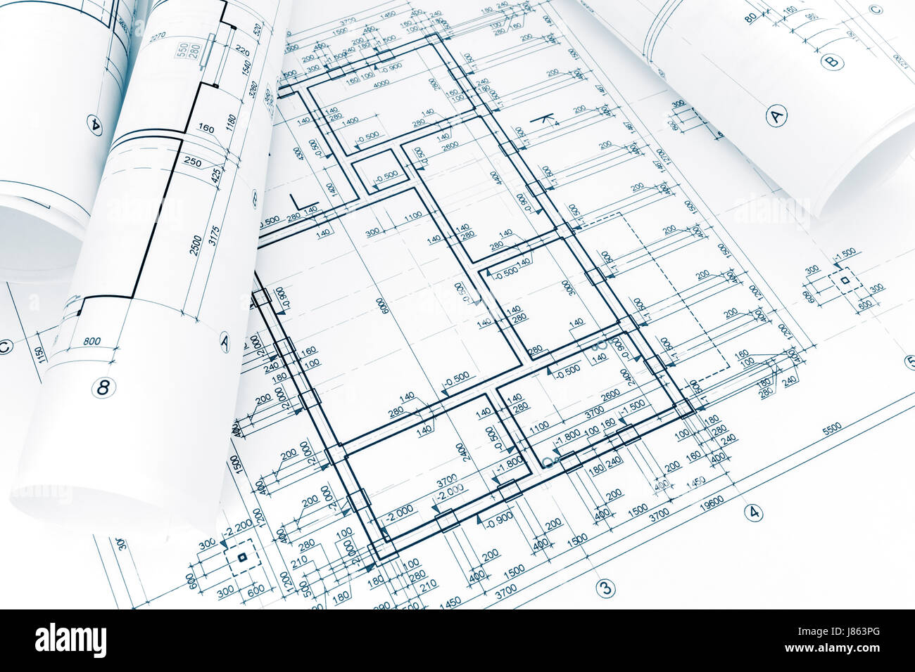 rolls of architectural project plans and blueprints with measurements Stock Photo
