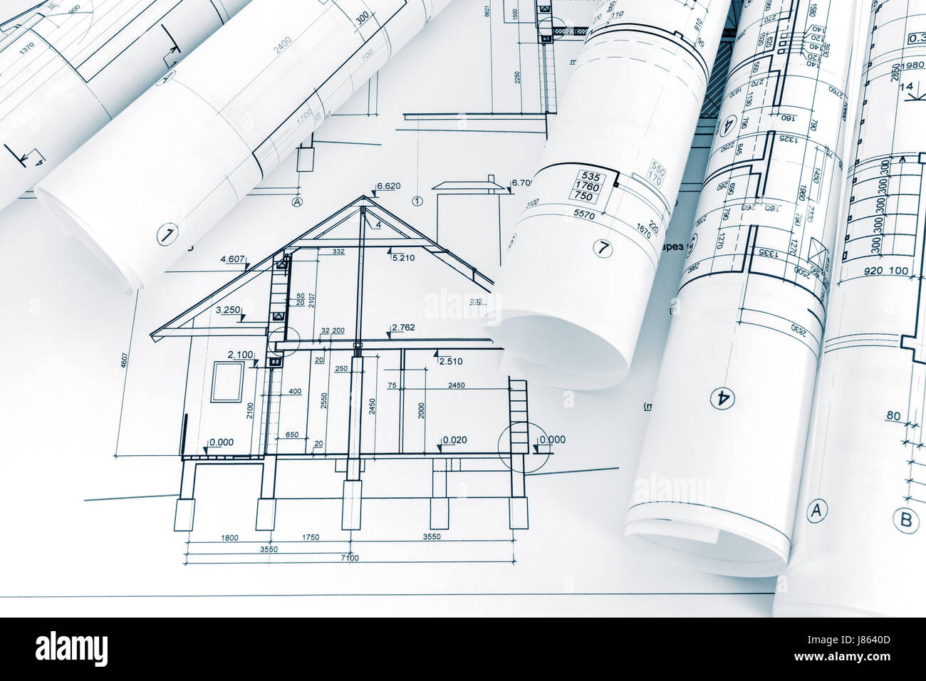 architectural project of new house and rolled blueprints on architect workplace Stock Photo