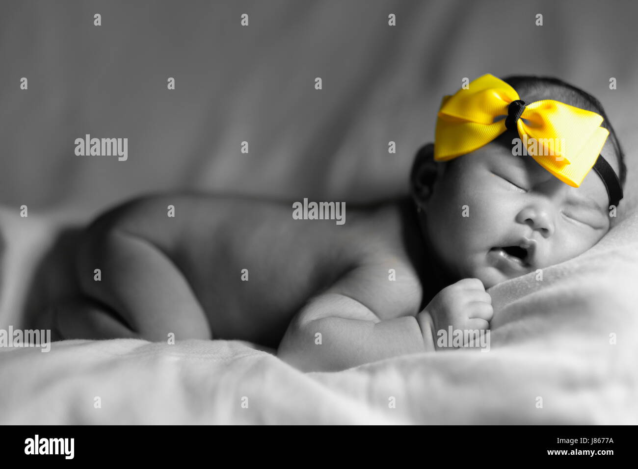 Newborn baby with yellow ribbon Stock Photo