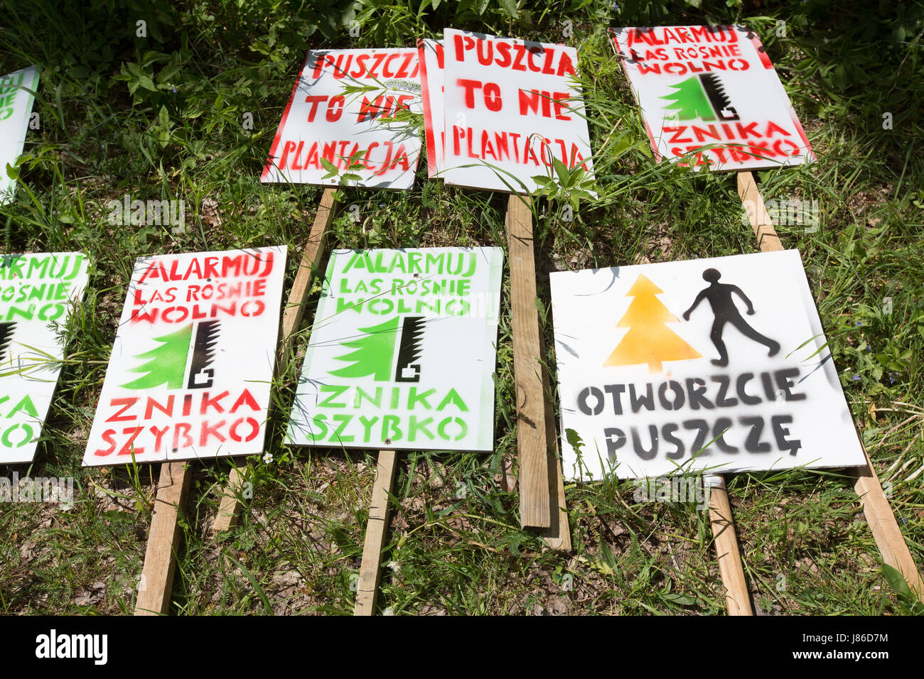 Bialowieza National Park, Poland. 27th May, 2017. Signs with protest slogans wait in the grass at the gathering area for a protest march of eco activists to be picked up by demonstrators, at Bialowieza National Park, Poland, 27 May 2017. With a march supported by Greenpeace activists wanted to protest against recent changes in the management plan for the Bialowieza National Park, that would allow for logging of 188 cubic meters of wood in the highly protected primevel forest. Photo: Jan A. Nicolas/dpa/Alamy Live News Stock Photo