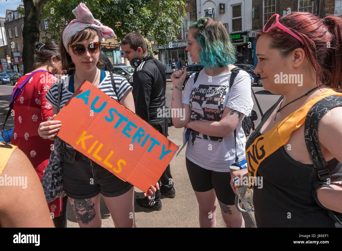 London, UK. 27th May 2017. A woman holds a postre 'Austerity Kills' as North London Sisters Uncut meet at Camden Rd station for their 'general election rally' in a protest against Tory budgets that have cut support for refuges for victims of domestic violence. After I left they marched to the now disused Holloway Prison, occupying the former visitors centre.  The intend to hold a week of workshops on women’s well being, self-defence and legal rights there before leaving. They say the former women's prison is public land and should be used for public good and not sold for building more luxury f Stock Photo