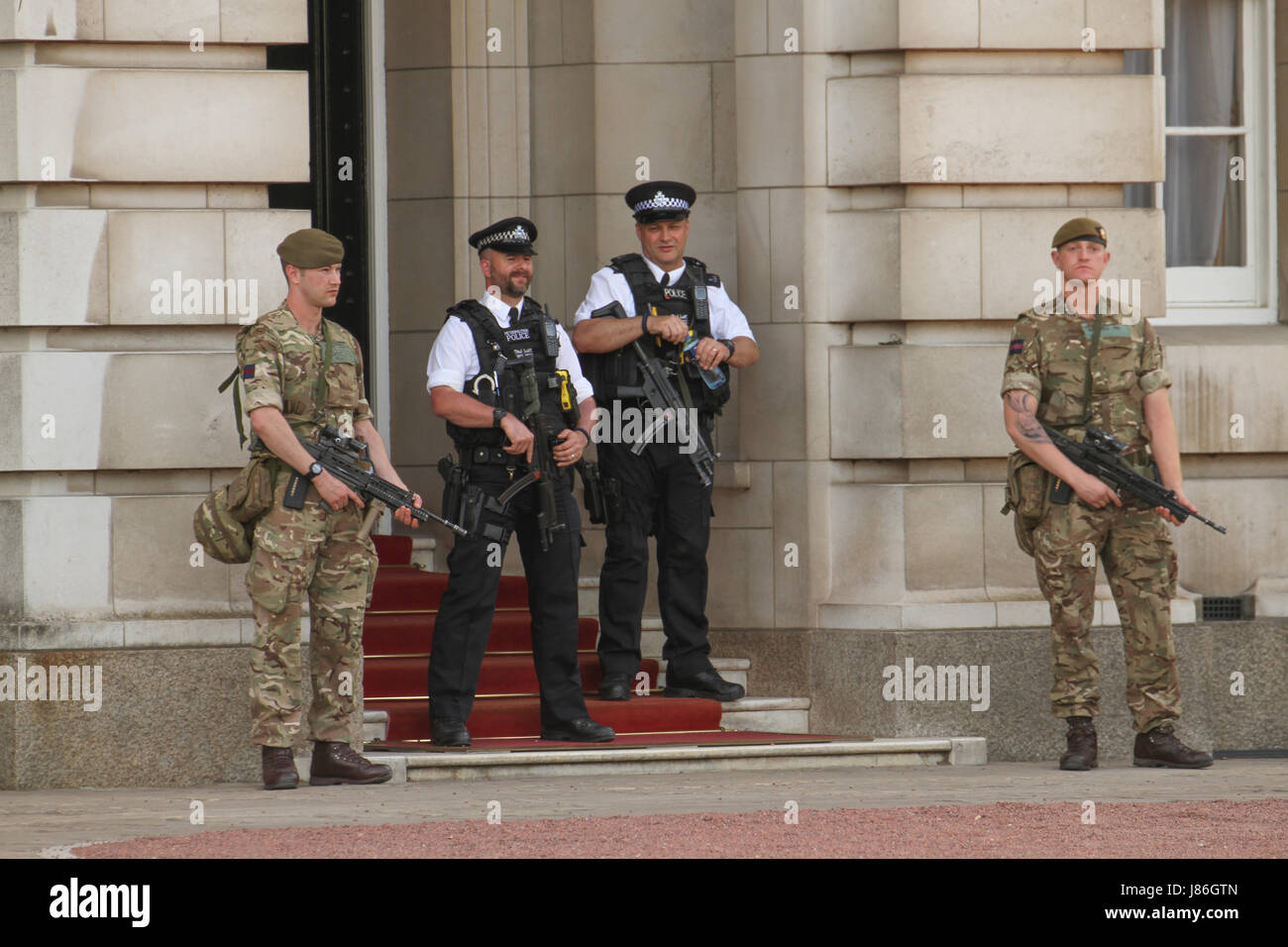 London, UK. 27th May, 2017. Soldiers and police officers carrying rifles on duty at Buckingham Palace after threat level was raised to critical, following the May 22nd Manchester Arena attack. About 1,000 armed military personnel were deployed to guarding national landmarks across the country. Credit: David Mbiyu/Alamy Live News Stock Photo