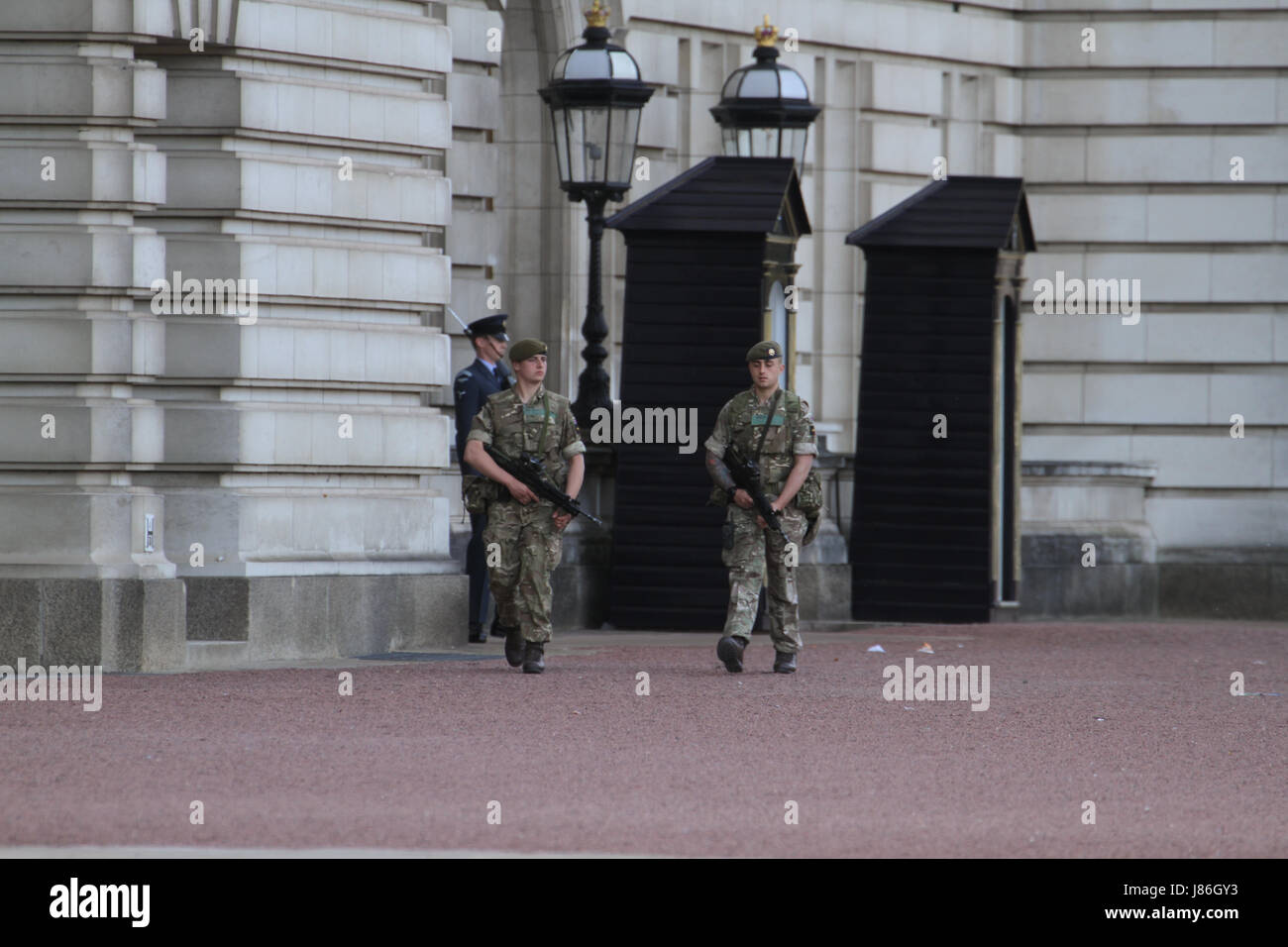 London, UK. 27th May, 2017. Soldiers carrying rifles march along Buckingham Palace front yard after threat level was raised to critical, following the May 22nd Manchester Arena attack. About 1,000 armed military personnel were deployed to guarding national landmarks across the country. Credit: David Mbiyu/Alamy Live News Stock Photo