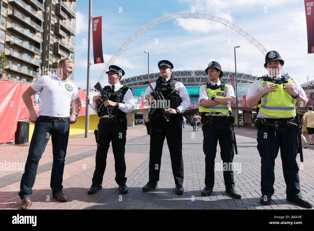 London, Britain. 27th May, 2017. Armed policemen are on patrol as security precautions are stepped up for Arsenal and Chelsea fans arriving at Wembley stadium for the FA Cup football finals in London, Britain, on May 27, 2017. The security level was in response to Manchester Arena bombing when 22 people died and 66 people were injured in one of the most deadly attacks in the UK. Credit: Ray Tang/Xinhua/Alamy Live News Stock Photo