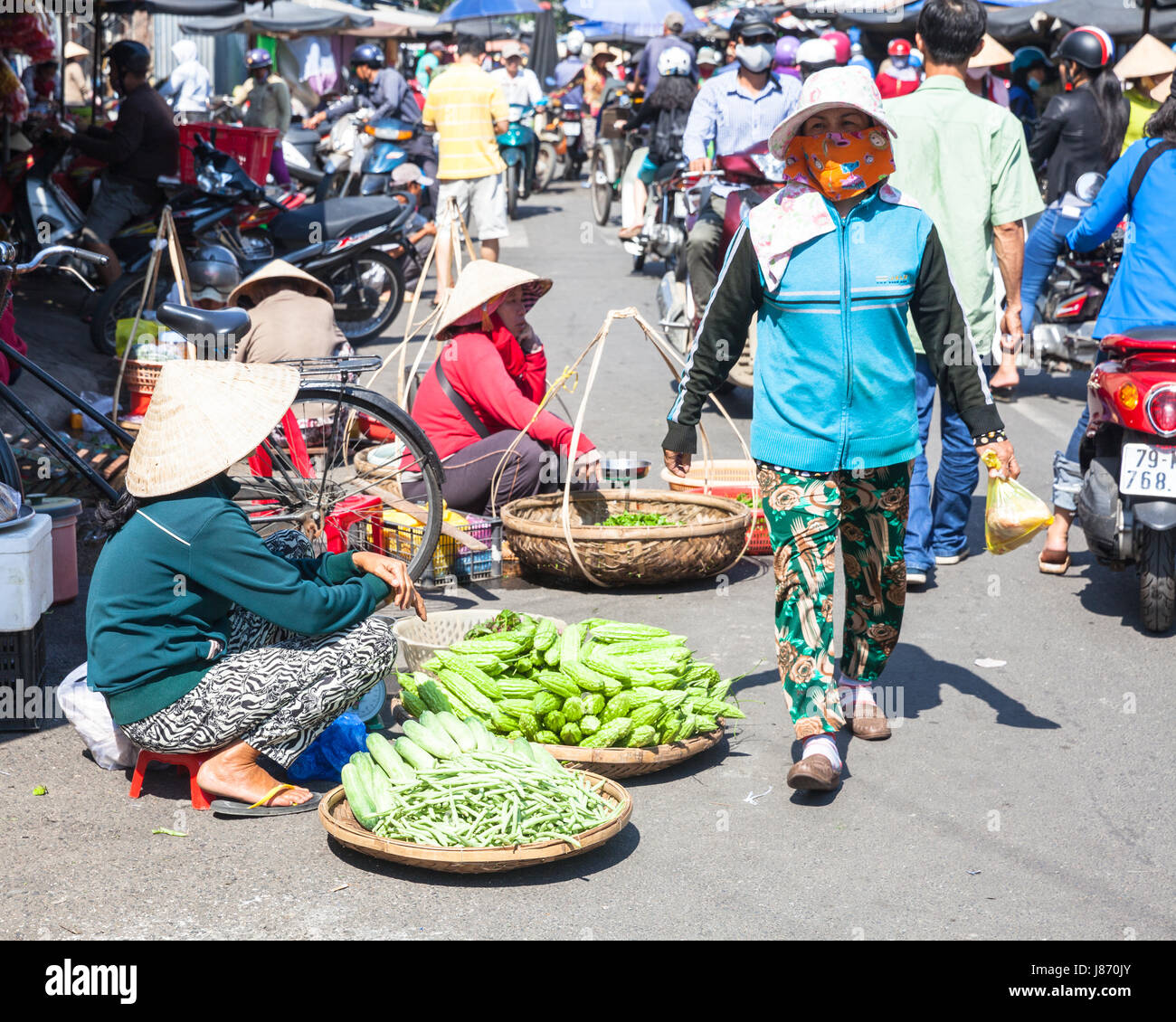 NHA TRANG, VIETNAM - JANUARY 20: Women are selling greens at the crowded market street on January 20, 2016 in Nha Trang, Vietnam. Stock Photo