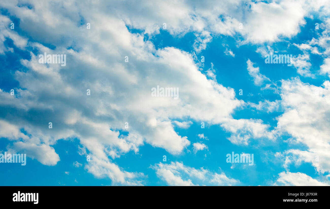Blue sky with puffy white clouds Stock Photo - Alamy